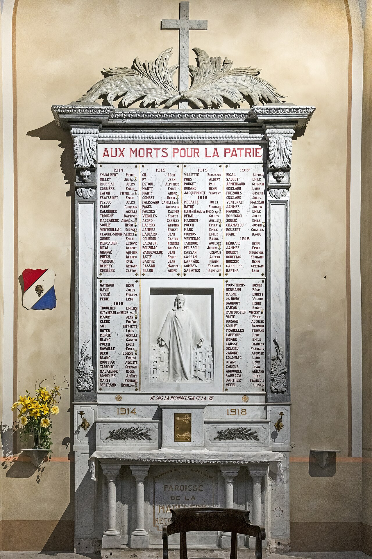 Ornate white marble World War I memorial with carved names and a central Christ relief