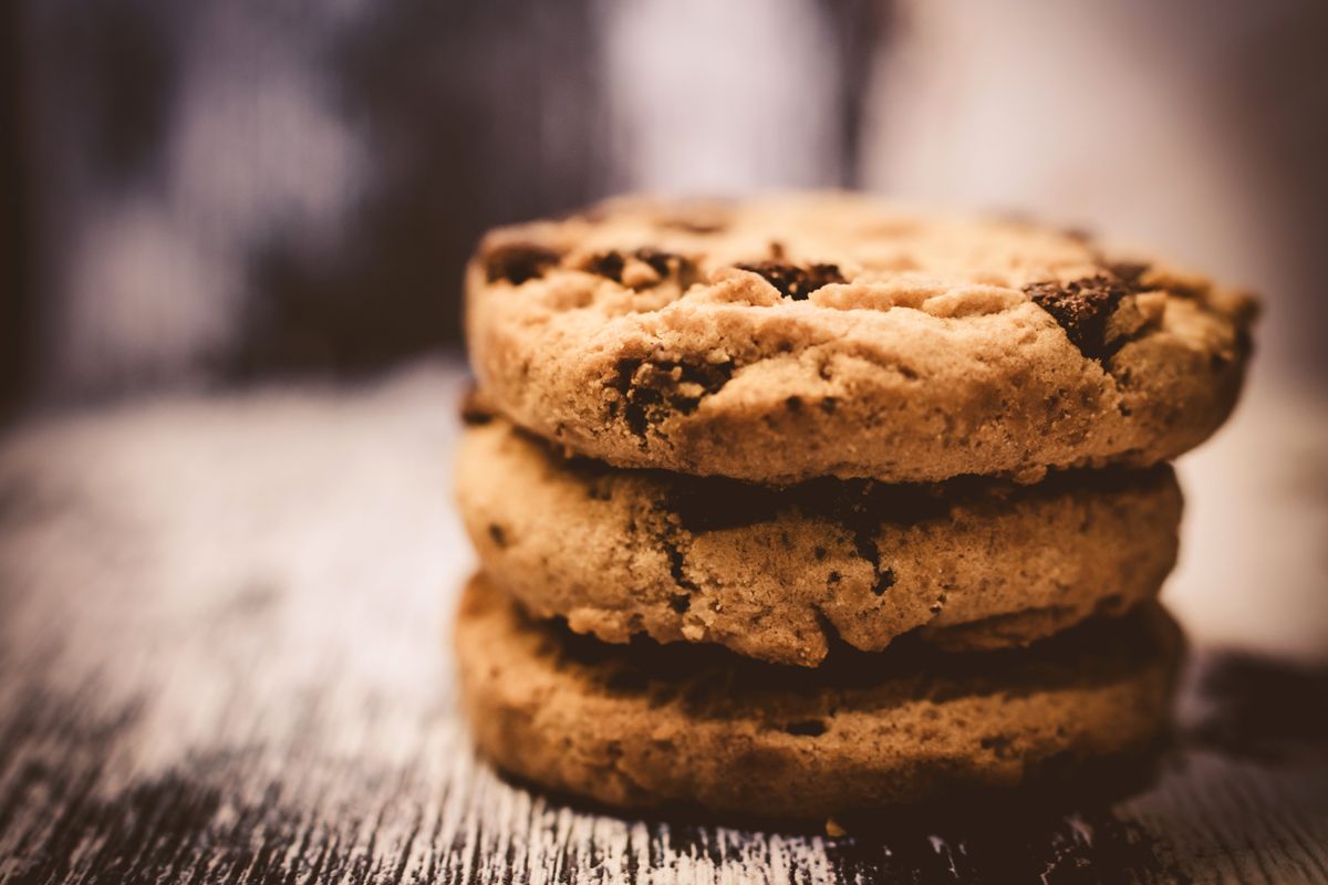 Stack of three thick golden-brown chocolate chip cookies with large chocolate chunks