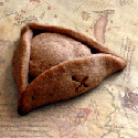 Brown triangular tricorne-hat cookie with an X on the brim resting on a vintage map